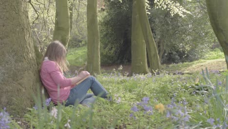 Woman-reading-a-book-in-woodland