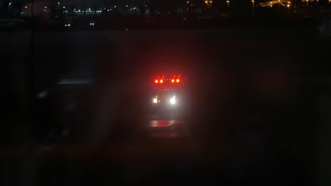 A-shot-of-an-ambulance-going-down-the-airport-runway-at-night