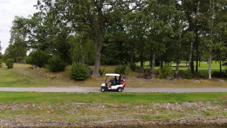 Golfspieler-Fahren-Zum-Nächsten-Abschlag,-Kamerafahrt-Aus-Der-Luft