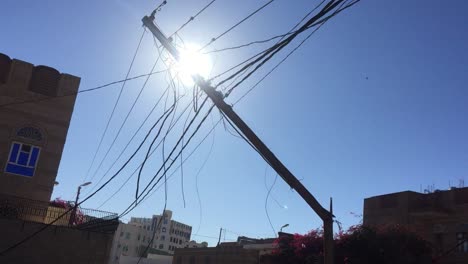 broken-electrical-pole-maybe-used-for-symbolic-videos-about-during-destruction-and-wars-in-Yemen-or-anywhere-else-with-sun-rays-in-background