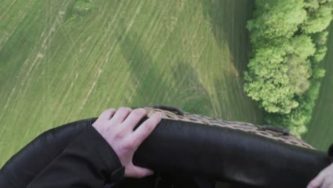 Close-up-of-hands-holding-wicker-basket-of-hot-air-balloon-during-first-flight,-cinematic-shot-of-emotions-in-the-sky