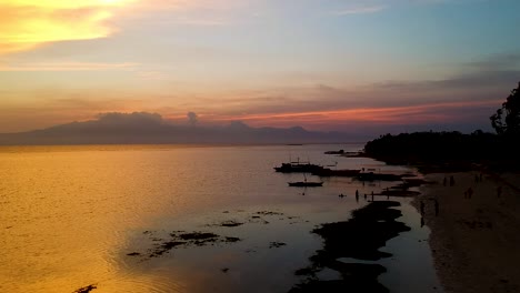 Aerial-of-epic-Sunset-and-silhouettes-of-boats-from-Paliton-Beach,-Siquijor,-Cebu,-Philippines