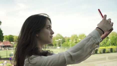 Joven-Italiana-Con-Smartphone-Tomando-Selfie-Al-Aire-Libre-En-Un-Parque-En-Londres