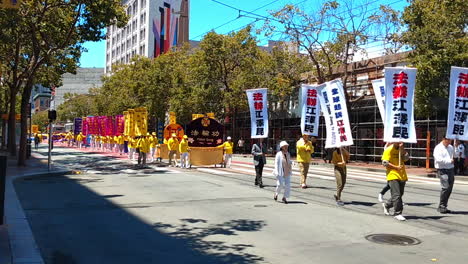 Falun-Dafa,-also-known-as-Falun-Gong,-practitioners-during-march-band-through-streets-of-downtown-in-San-Francisco-protesting-against-religious-persecution-from-chinese-communist-party-of-Jiang-Zemin