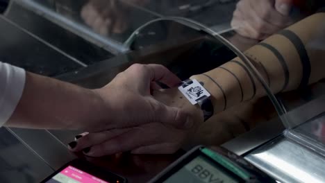 Adjusting-a-festival-wristband-and-topping-it-up-with-a-smartphone