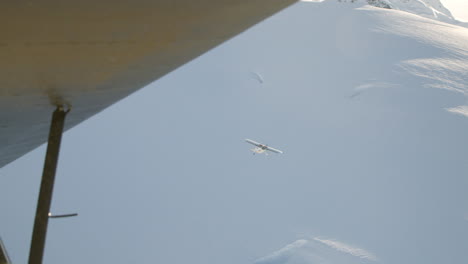 Aerial-Follow-small-airplane-over-snow-field