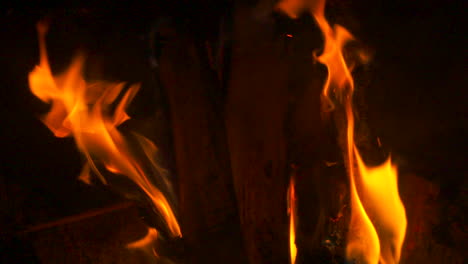 Slow-motion-close-up,-flames-burning-around-a-log-in-a-fireplace