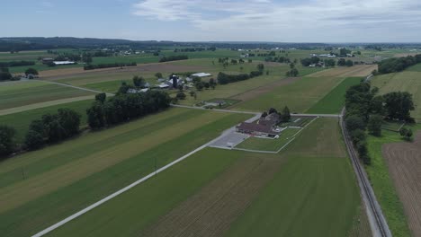 Vista-Aérea-De-La-Tierra-Agrícola-Amish-Por-Vía-Férrea
