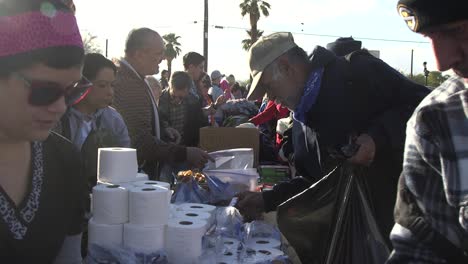 Obdachloser-Bekommt-Toilettenpapier-Von-Der-Gemeinnützigen-Organisation,-Phoenix-Arizona-Konzept:-Wohltätigkeit,-Zurückgeben,-Mittellos
