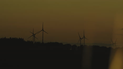 Schwenk-über-Windkraftanlagen-Im-Hochland-Bei-Sonnenuntergang-Mit-Schönem-Warmen-Und-Gelben-Licht