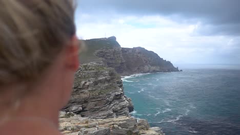 Slowmotion-OTS-of-Blonde-Millenial-Woman-overlooking-Cape-of-Good-Hope-near-Capetown