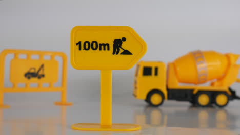 Construction-sign-illustration,-construction-site,-truck-and-equipment,-toy-miniature-model,-background-cinematic-concept-of-creative-mini-figurine-of-workplace