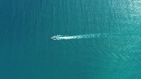 Luftaufnahme-Von-Longtail-Booten,-Die-Auf-Kristallklarem-Wasser-Entlang-Des-Sandstrandes-In-Thailand-Schwimmen