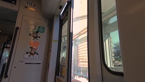 Geschwindigkeitsrampe-An-Einer-Der-Stadtbahnstationen-Der-Phoenix-Metro,-Ein-Einsamer-Mann-In-Einem-Hoodie-Geht-An-Der-Offenen-Zugtür-Vorbei,-Die-Sich-Schließt-Und-Der-Zug-Abfährt