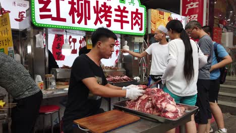 Xian,-China---July-2019-:-Butcher-sharpening-knife-to-cut-fresh-meat-on-a-streetfood-market-in-popular-Muslim-Quarter