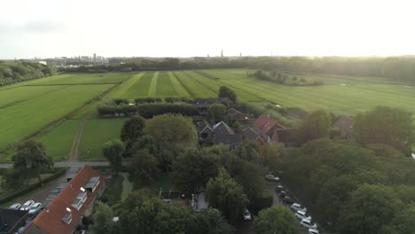 Aerial-of-a-Small-Dutch-Town-during-Sunset-with-Green-Countryside-in-the-Background-and-Trees