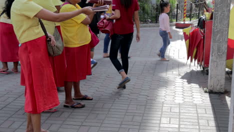Mujeres-Con-Uniforme-Amarillo-Rojo-Trabajando-En-Las-Calles,-Vendiendo-Folletos,-Turistas-Cazando-Biblias