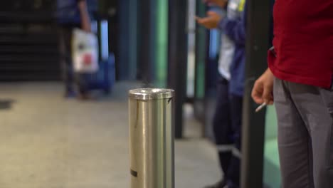 Gente-En-La-Sala-De-Fumadores-En-Un-Aeropuerto,-Sosteniendo-Cigarrillos