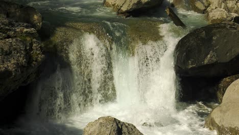 Cold-water-of-mountain-stream-cascading-over-rocks,-close-up