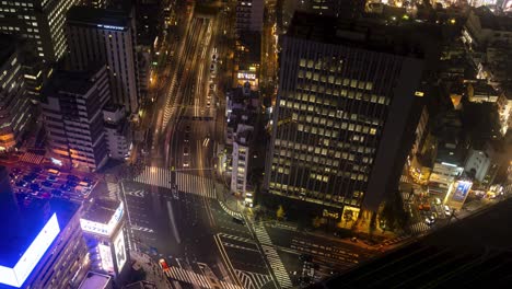 Tokyo-night-time-lapse-traffic-and-people-moving-through-a-very-active-city,-top-down-view
