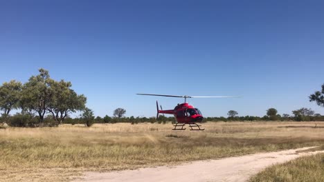 Roter-Medizinischer-Hubschrauber-Hebt-Vom-Straßenrand-In-Der-Botswana-Savanne-Ab