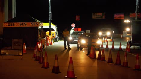 Camiones-Detenidos-Por-Un-Policía-En-El-área-Del-Puesto-De-Control-Para-Su-Inspección-Por-La-Noche---Restricciones-De-Viaje-Covid-19-En-Australia---Tiro-Completo