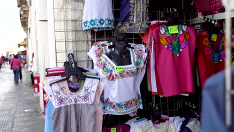 Camera-pushes-in-and-rotates-showing-Mexican-blouses-for-women-in-a-store-in-Merida,-Mexico