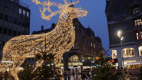 Illuminated-reindeer-on-square-in-Copenhagen-city-at-Christmas-time,-panning-shot