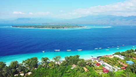 Vivid-colors-of-blue-azure-sea-stream-between-two-tropical-islands-with-lush-vegetation-and-white-sandy-beaches-in-Gili,-Indonesia