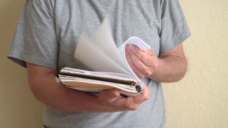 Person-flipping-through-pages-of-a-note-book