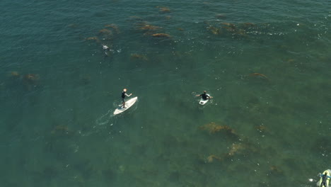 Paddle-Boarder,-Surfers-and-Frogman-off-the-coast-of-Surfrider-Beach-in-Malibu-California