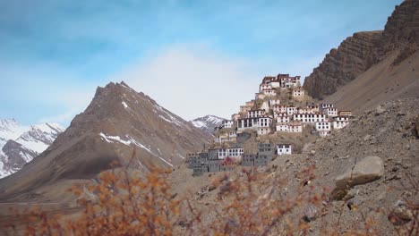 A-Picturesque-View-of-Key-Monastery-in-the-Spiti-Valley-as-seen-during-Trekking-from-Key-Village,-Near-Indo-China-Border,-in-North-India-with-Dry-Grass-and-Clear-Weather-Sky-in-the-Background