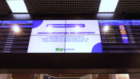 Information-board-at-Santos-Dumont-city-airport-of-domestic-flights-with-departure-schedule-and-instructions-regarding-preventitive-measures-regarding-COVID-19-virus-outbreak-such-as-using-a-face-mask