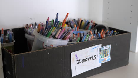 Box-Full-Of-Colored-Art-Pencils-On-A-Shelf,-TILT-UP