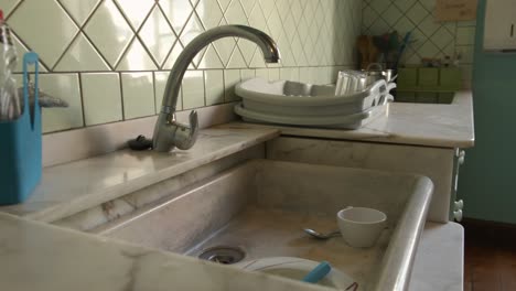 Old-type-kitchen-dolly-zoom-shot-revealing-the-marble-sink-with-some-dishes-to-be-washed