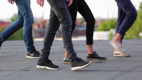 Legs-Of-People-Walking-On-The-Roof-Of-An-Urban-Building