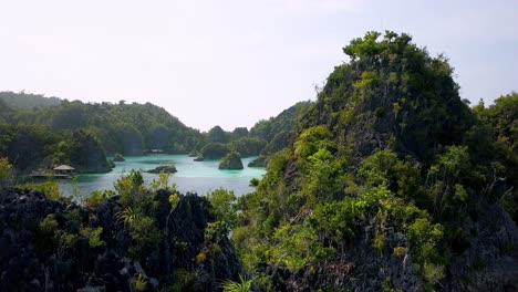 Muelle-De-Llegada-Azul-En-La-Laguna-De-Las-Islas-Piaynemo-En-Raja-Ampat-Indonesia,-Tiro-Aéreo