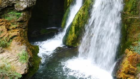 Gesperrte-Aufnahme-Eines-Schönen-Wasserfalls-In-Einer-Schlucht,-Umgeben-Von-Grüner-Vegetation