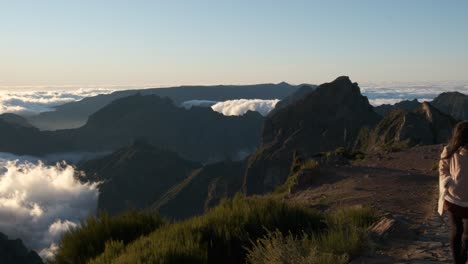 Asian-young-girl-walks-on-a-stone-path-above-the-clouds-on-the-Pico-do-Ariero-trail-in-Madeira