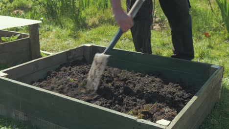 breaking-up-soil-with-shovel-raised-garden-bed