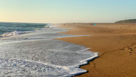 Wellen,-Die-Während-Des-Sonnenuntergangs-In-Nazare,-Portugal,-An-Die-Küste-Schlagen
