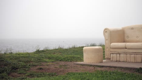 Gedenkskulptur-Eines-Sofas-Am-Küstenvorland,-Schwenk-Nach-Rechts