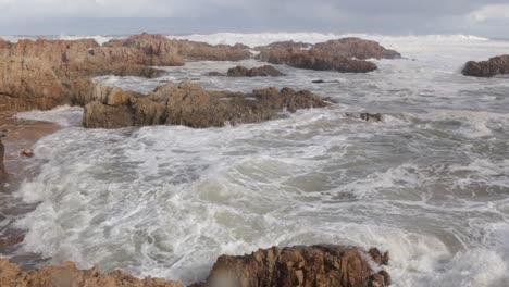 Pan-left-as-powerful-wave-surges-onto-rocky-South-African-shoreline