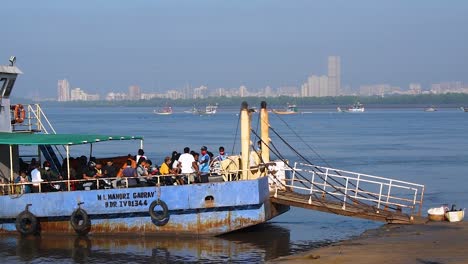 A-small-ferryboat-with-passengers-and-crew-waiting-for-more-people-and-passengers-near-a-harbor-or-port-video-background