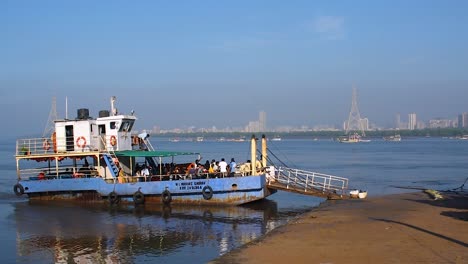 A-small-ferryboat-or-ro-ro-ferry-with-passengers-and-crew-waiting-for-more-people-and-passengers-near-a-harbor-or-port-video-background
