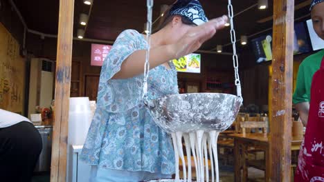 Woman-making-traditional-chinese-noodles-on-the-food-stall-in-Feng-Huang-old-town
