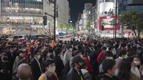 Huge-Crowd-Of-People-Wearing-Masks-At-Shibuya-Crossing-On-Halloween-Night-In-Tokyo---high-angle,-slow-motion