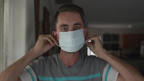 Young-man-putting-on-covid-pandemic-mask
