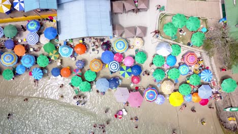 Aerial-jib-down-shot-of-the-Praia-da-Sepultura-crowded-of-tourists-on-the-high-tourism-season