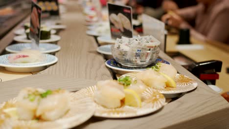 Sushi-De-Cinta-Transportadora---Variedad-De-Sushi-Servido-En-Platos-Que-Se-Mueven-En-La-Cinta-Transportadora-Dentro-Del-Restaurante-Kaitenzushi-En-Kyoto,-Japón